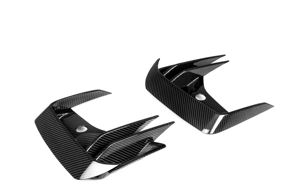 Carbon fiber car parts featuring sharp, angular fins and glossy finish; positioned against a plain white background, highlighting their sleek design and modern material.
