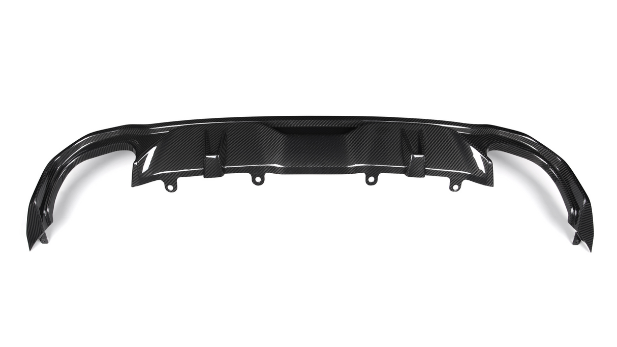 A carbon fiber rear diffuser with multiple fins is positioned horizontally, intended for aerodynamic improvement in a vehicle setting. The background is plain and white.