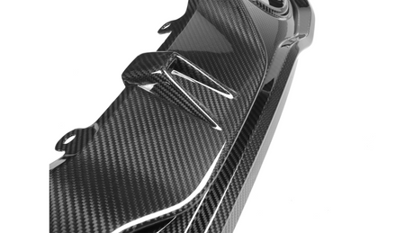 A glossy carbon fiber car part with aerodynamic fins is shown against a plain white background, emphasizing its sleek and modern design.