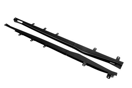 Two long, black carbon fiber car side skirts with mounting brackets lie on a white background. One piece features the text "500000."