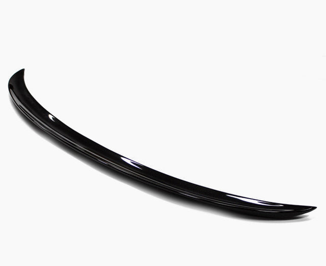 A sleek, black car spoiler with a smooth, curved design rests on a plain white background, highlighting its glossy finish and aerodynamic shape.