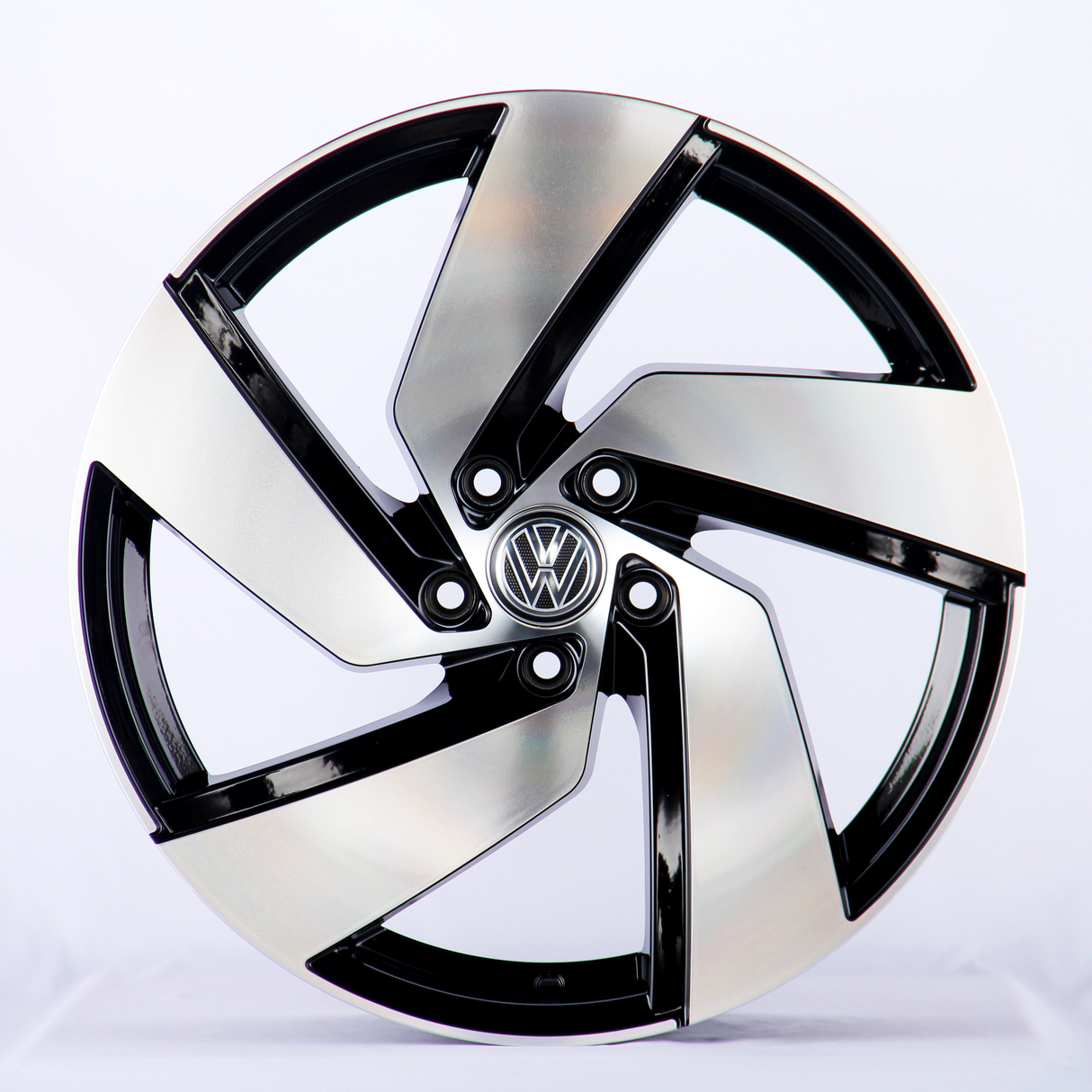 A metallic car wheel with a five-spoke design featuring a central logo; it rests against a plain white background.