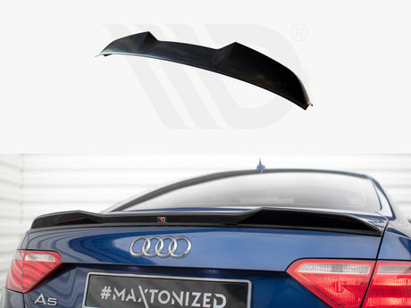 A black car spoiler is displayed above a blue Audi A5, enhancing aerodynamics. The rear of the car, parked indoors, shows taillights and badges. Text: "#MAXTONIZED."