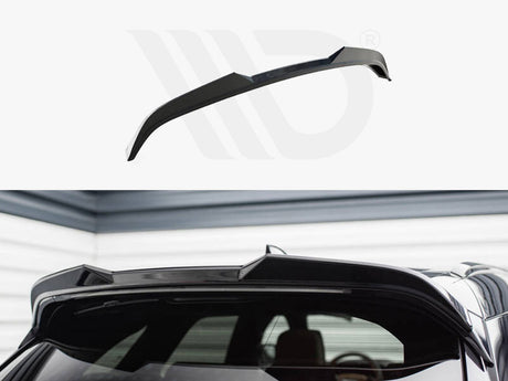Black car roof spoiler installed on the rear of a vehicle, enhancing aerodynamics. The setting is a garage with gray and white walls, creating a sleek, modern atmosphere.