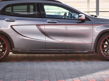 A gray car with red accented wheels is parked on a patterned pavement. The vehicle's side features a bold contour design and visible text "X2 ARTE" near the front wheel.
