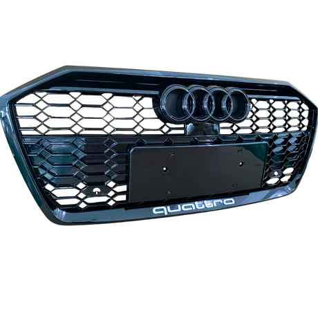 A black car grille displays three circular emblems at the top and “quattro” text at the bottom, featuring a honeycomb pattern.