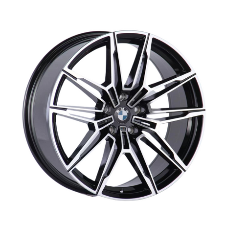 A black and silver alloy car wheel displayed upright against a plain white background. The wheel's design features intricate, angular spokes, radiating from a central hub with a logo.