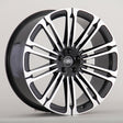 A black and silver Land Rover alloy wheel with multiple spokes is displayed against a plain gray background. The center cap features the "LAND ROVER" logo in white text.