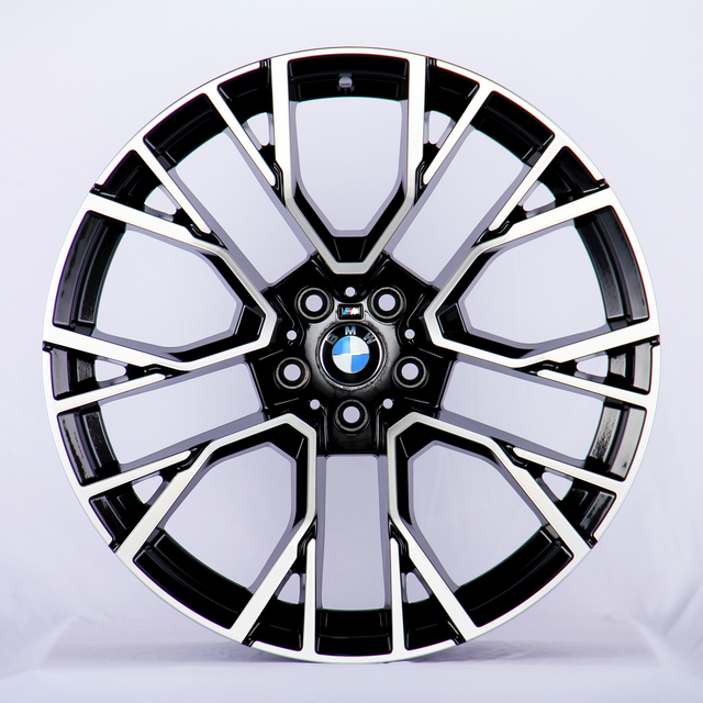 A black and chrome car wheel rim, with intricate geometric patterns, displaying the BMW logo at its center; set against a plain white background.