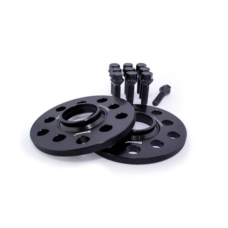 Two black wheel spacers with multiple holes rest on a white surface, accompanied by ten black bolts standing upright. The spacers are labeled "Bimmec" and "4Lug-5mm."