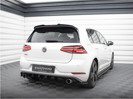A white Volkswagen GTI is parked on a checkered floor in a bright, industrial-style room. The car has dual exhausts and black wheels. Text: "#MAXTONIZED" on the license plate area.