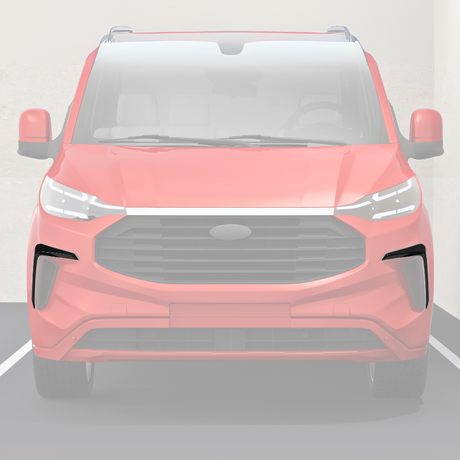 A red car is parked in a parking space, viewed head-on, displaying a large grille and modern headlights. The background shows a concrete wall.