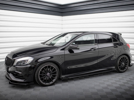 A sleek black hatchback car is parked in a modern garage with textured white and grey walls, featuring glossy black rims and tinted windows.