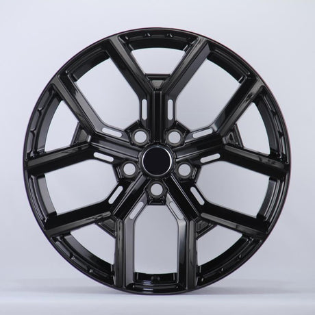 Black, glossy, multi-spoke alloy wheel; resting upright in a well-lit studio setting; casting a slight shadow on the white background.
