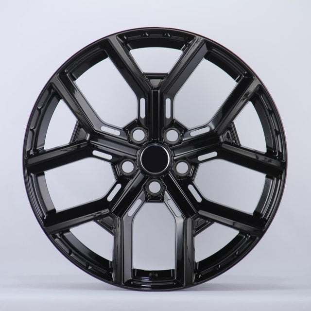 Black, glossy, multi-spoke alloy wheel; resting upright in a well-lit studio setting; casting a slight shadow on the white background.