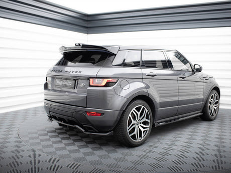A gray Range Rover is parked on a checkered floor in a well-lit space, featuring "RANGE ROVER" text on the back and a license plate reading "#MAxtonized".