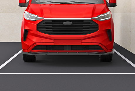 A red van is parked in an empty parking space with beige walls. The front view shows the grille and headlights, with no visible text.