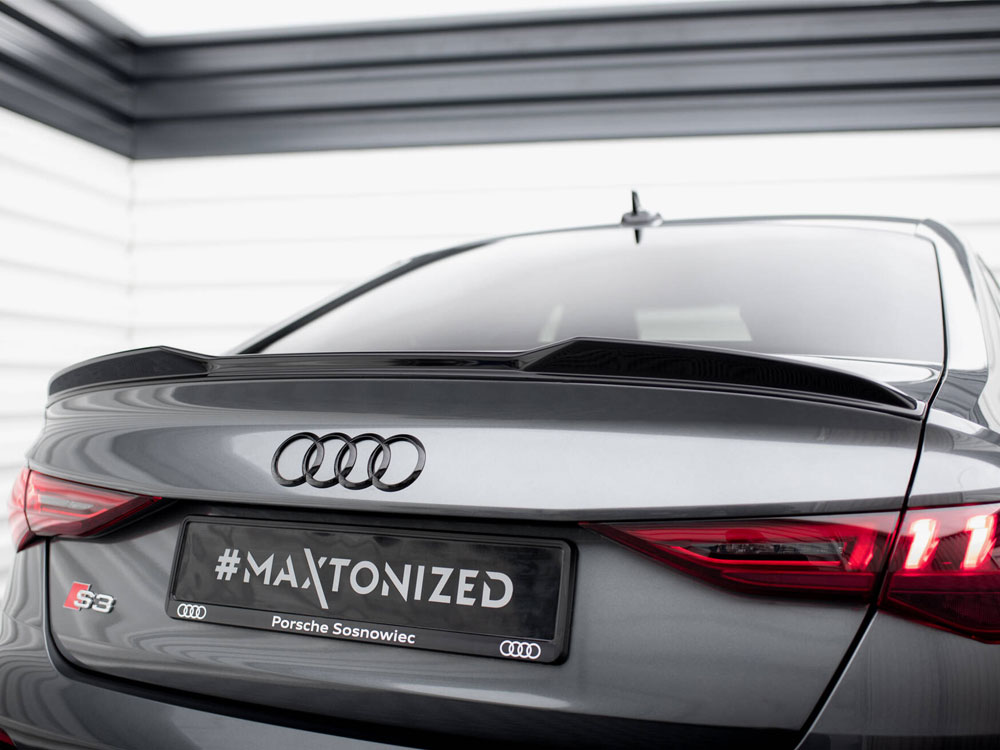 A gray Audi S3 car is parked in a garage. The rear features a spoiler, highlighted by red taillights, with a license plate reading "#MAXTONIZED Porsche Sosnowiec."