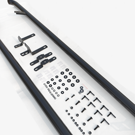 Two long black metal bars lie on a white surface, accompanied by various brackets, washers, screws, nuts, and other hardware components arranged systematically.