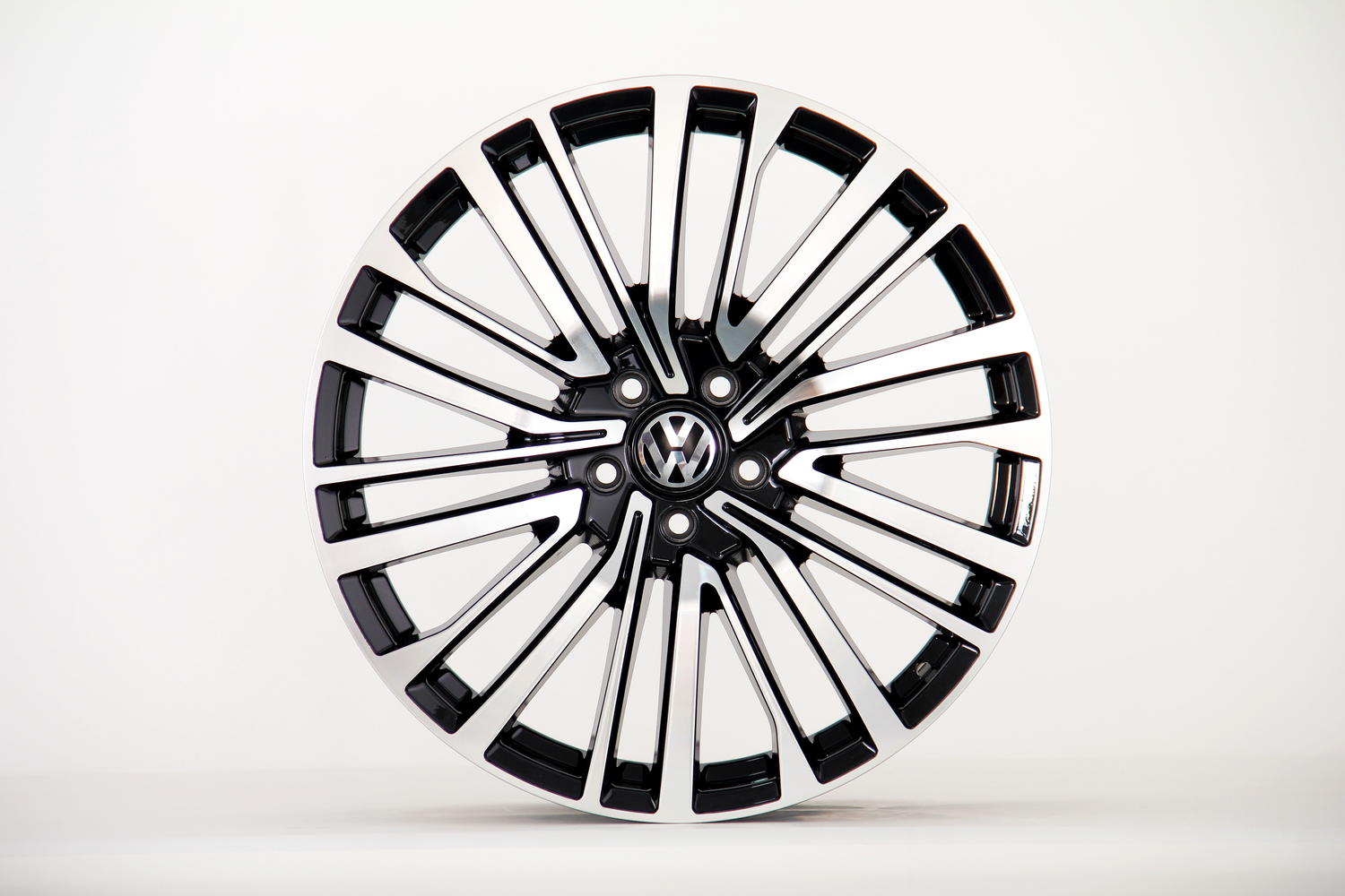 A polished alloy wheel with a modern, multi-spoke design, featuring a "VW" logo at the center, is displayed against a plain white background.