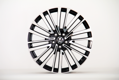A polished alloy wheel with a modern, multi-spoke design, featuring a "VW" logo at the center, is displayed against a plain white background.