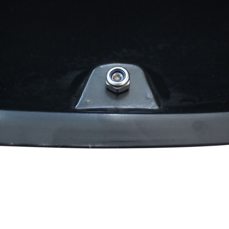 A metal bolt is fixed onto a flat black and gray surface, surrounded by dark background.
