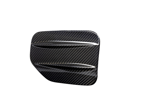A carbon fiber automotive vent cover, angled with diagonal slats, displayed against a plain white background, emphasizing its glossy, textured surface.