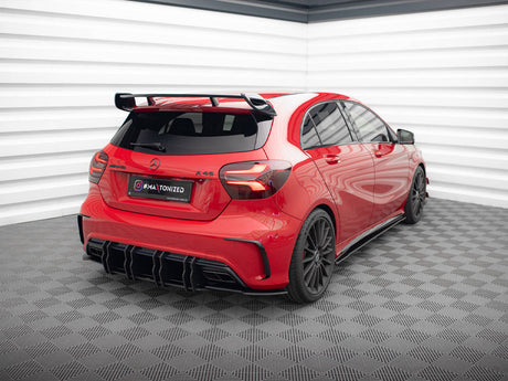 Red car with black accents sits stationary in a checkered-floor garage. Text on the plate reads "#MATONIZED." The walls are white with a layered design.