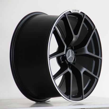 A black alloy wheel features a multi-spoke design with a Mercedes emblem at the center, placed against a simple white background.