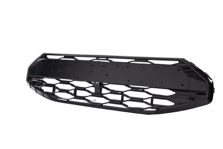 A black car front grille with a hexagonal mesh pattern is isolated against a white background. The grille has a solid center plate, likely for mounting purposes.