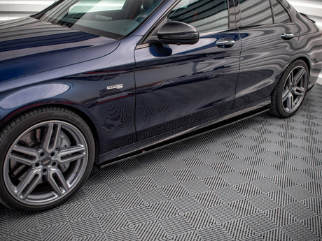 Car side view, parked in a garage with patterned flooring. The shiny, dark-colored vehicle displays "BITURBO" on the front side panel, highlighting a performance feature.