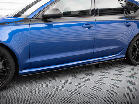 A blue car with "Audi Sport" text on the side stands on a checkered floor. The vehicle is viewed from the side, displaying its sleek design and black wheels.