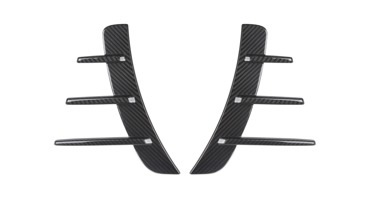 Carbon fiber car vent accents, featuring a central vertical piece with five horizontal fins, rest against a white background, showcasing their sleek and modern design.