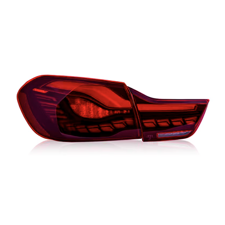 A red car taillight with a sleek, modern design rests on a plain white background, reflecting subtle shadows underneath.