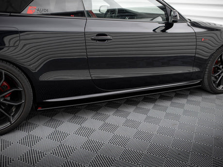 Car side with black body featuring red and black wheels, parked on a patterned floor; decals read "AUDI ELITE" and "mygermansports.com" on the window.