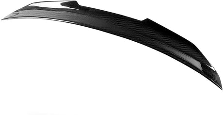 A curved, black carbon fiber car spoiler with a glossy finish rests against a plain white background, showcasing its aerodynamic design and texture.