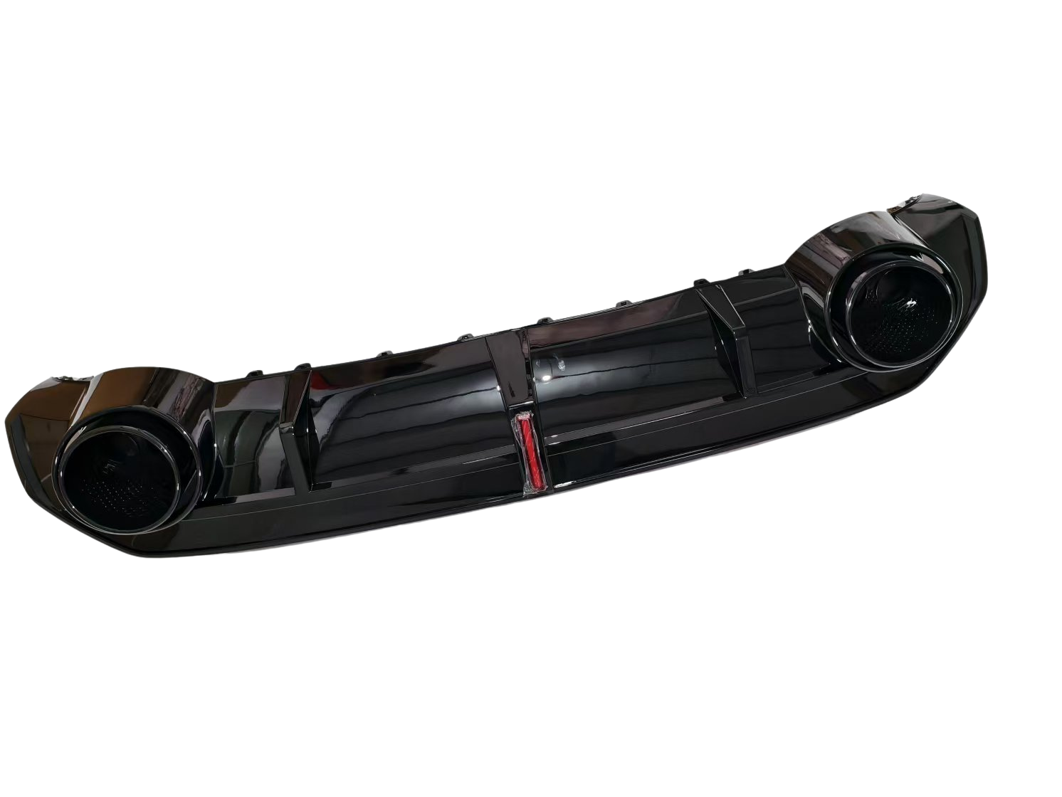A glossy black car bumper with two circular exhaust openings is displayed against a white background.