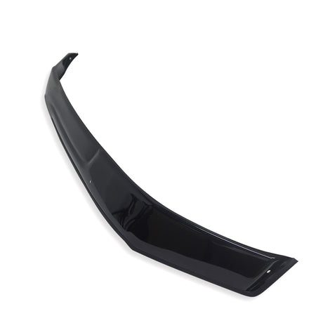 A glossy black car spoiler lies diagonally on a plain white background, showcasing its sleek, curved design and aerodynamic structure.