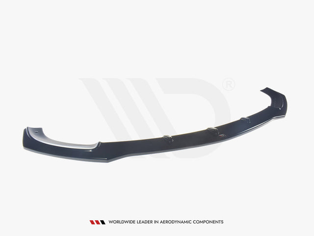 A black aerodynamic car component, resembling a front splitter, rests on a plain white background. Text below reads: "WORLDWIDE LEADER IN AERODYNAMIC COMPONENTS."