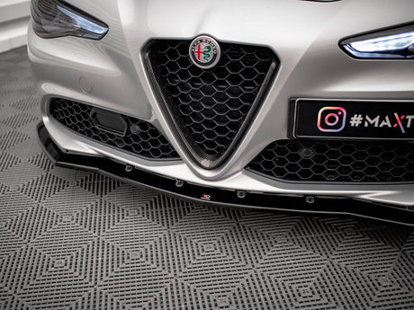 Car front with Alfa Romeo badge and honeycomb grille, parked on a patterned floor. License plate displays "@MAXTUNE" with Instagram logo.