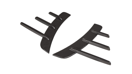 Two curved carbon fiber car diffusers with vertical fins, lying against a white background.