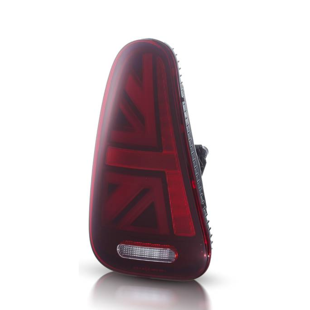 A triangular red car taillight features a Union Jack pattern and a clear section, standing upright against a plain, light background.