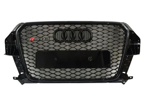 A black car grille features a honeycomb mesh design with the Audi four-ring emblem and "RS Q3" badge, set against a plain white background.