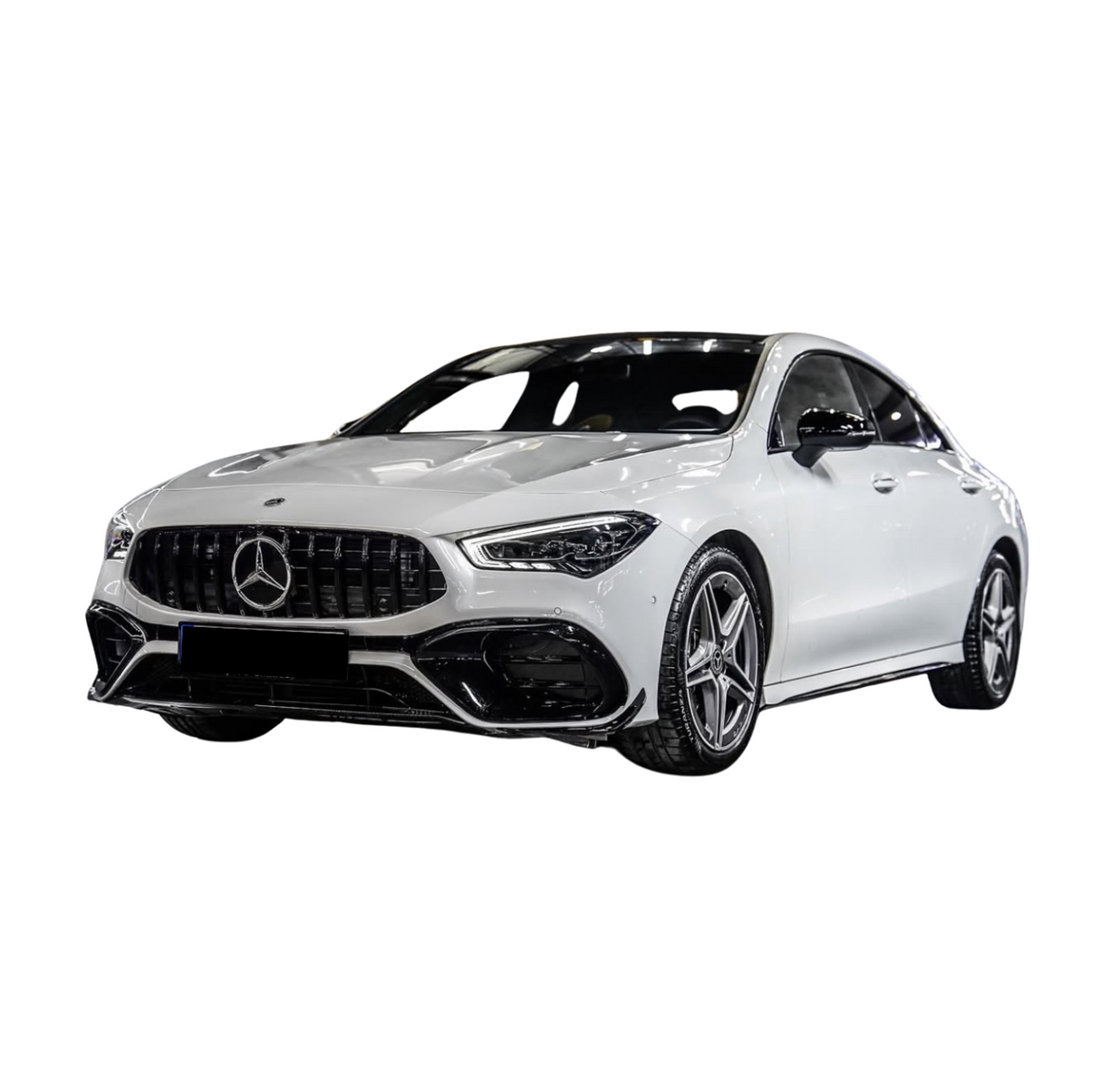 A white Mercedes sedan with a sleek design and star emblem grille is parked, showcasing its modern styling and five-spoke alloy wheels against a plain white background.