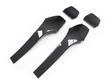 Two elongated, glossy carbon fiber panels and two smaller matching pieces lie on a plain white surface, reflecting light.