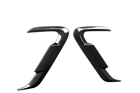 Two curved, carbon fiber-textured car accessory pieces facing each other, against a white background. They feature glossy, reflective surfaces with an angular, aerodynamic design.