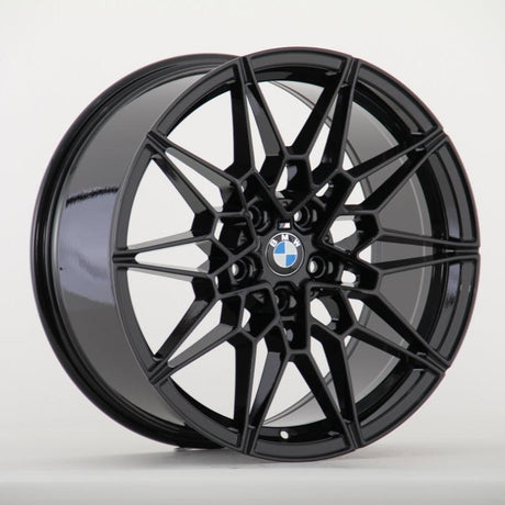 A glossy black alloy wheel with intricate geometric spokes features a centered BMW logo. It is positioned against a plain white background.