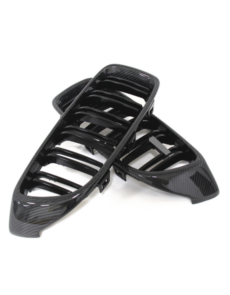 Two black car grilles with a glossy carbon fiber finish are stacked on a white background, showcasing a sleek, modern design with multiple horizontal slats.