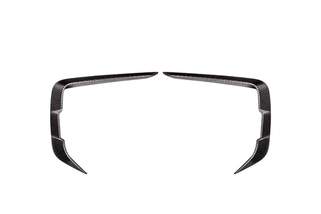 Two symmetrical, angled carbon fiber trim pieces facing each other on a plain white background, resembling elongated, curved brackets or stylized boomerangs.