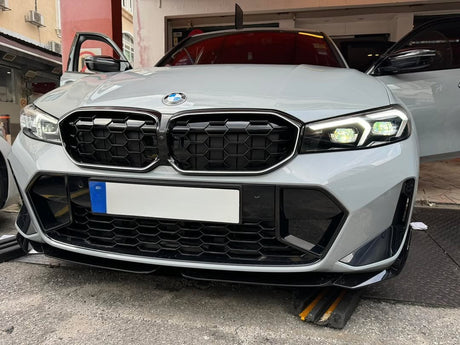 A white car with a prominent front grille and illuminated headlights is parked on a street. The environment includes a building with open doors and visible architectural details.